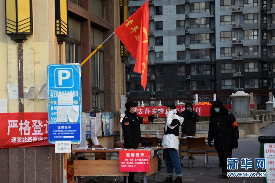 在河北省三河市燕京航城社区门口,居民在接受体温检测(2月23日摄)